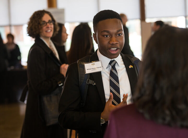 EMERGE scholar talking to people at an event